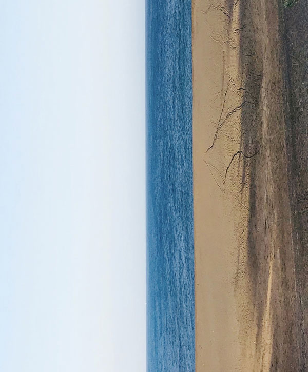 Blick auf Meer um 90º gedreht, Kanaren Flagge Farben weiss blau gelb zu erkennen