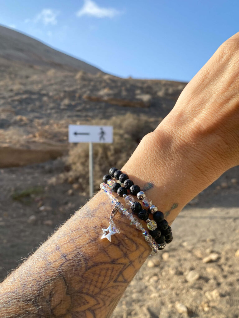 Handgelenk mit Lava Armbänder vor Vulkanlandschaft